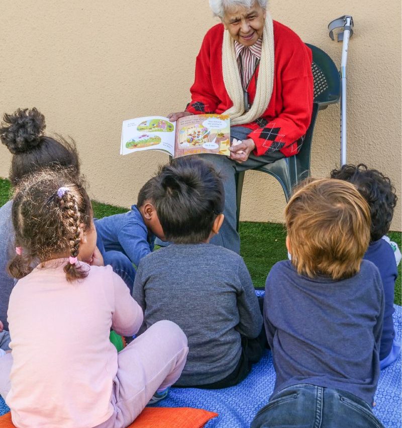 elderly woman reading to children