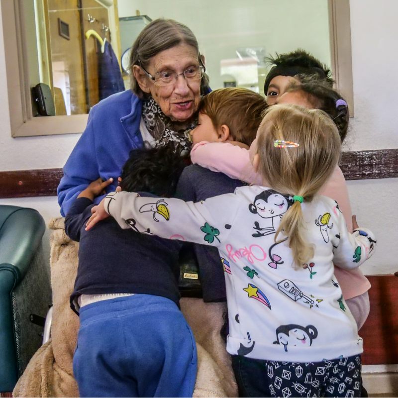 elderly woman hugging children